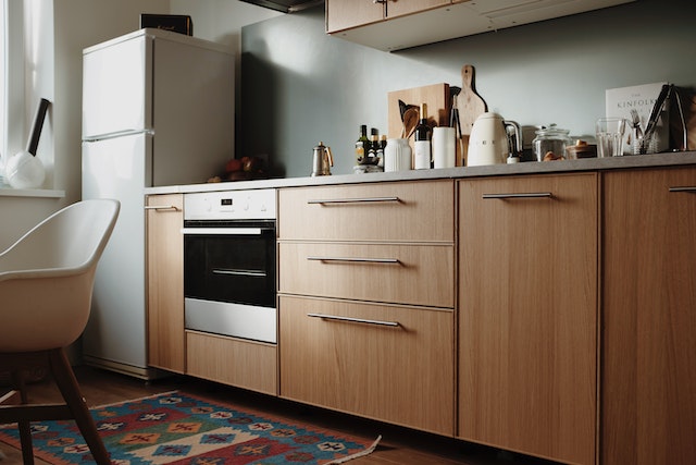 small kitchen with a white fridge and wooden cabinet